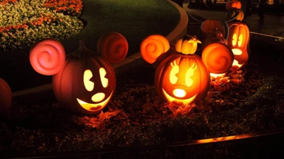 Abóboras de Halloween caprichosas com rostos do Mickey e da Minnie iluminadas à noite