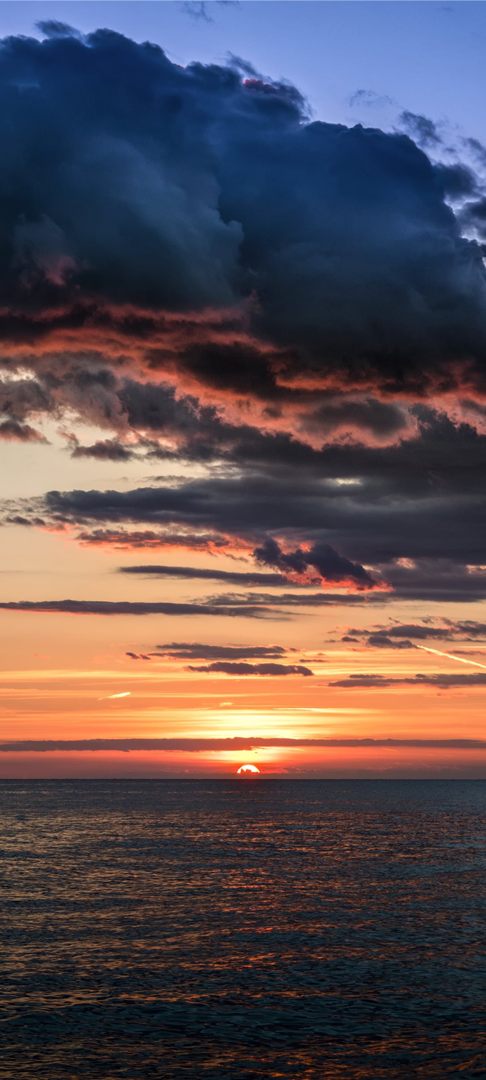 Atardecer sobre el océano con un bote solitario en la distancia (atardecer, ios, nube, agua, atmósfera)