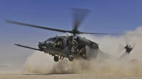 El helicóptero Sikorsky UH-60 Black Hawk realiza operaciones de búsqueda y rescate en combate en terreno polvoriento.