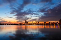 Paysage urbain au crépuscule : Reflets vibrants du coucher de soleil sur des eaux tranquilles