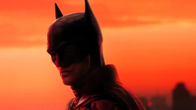 Batman em silhueta contra um pôr do sol flamejante