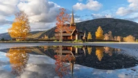 Reflexões serenas do outono: Uma igreja à beira do lago entre montanhas e folhagem colorida