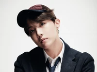 J-Hope: Rapper sul-coreano estiloso com boné e terno