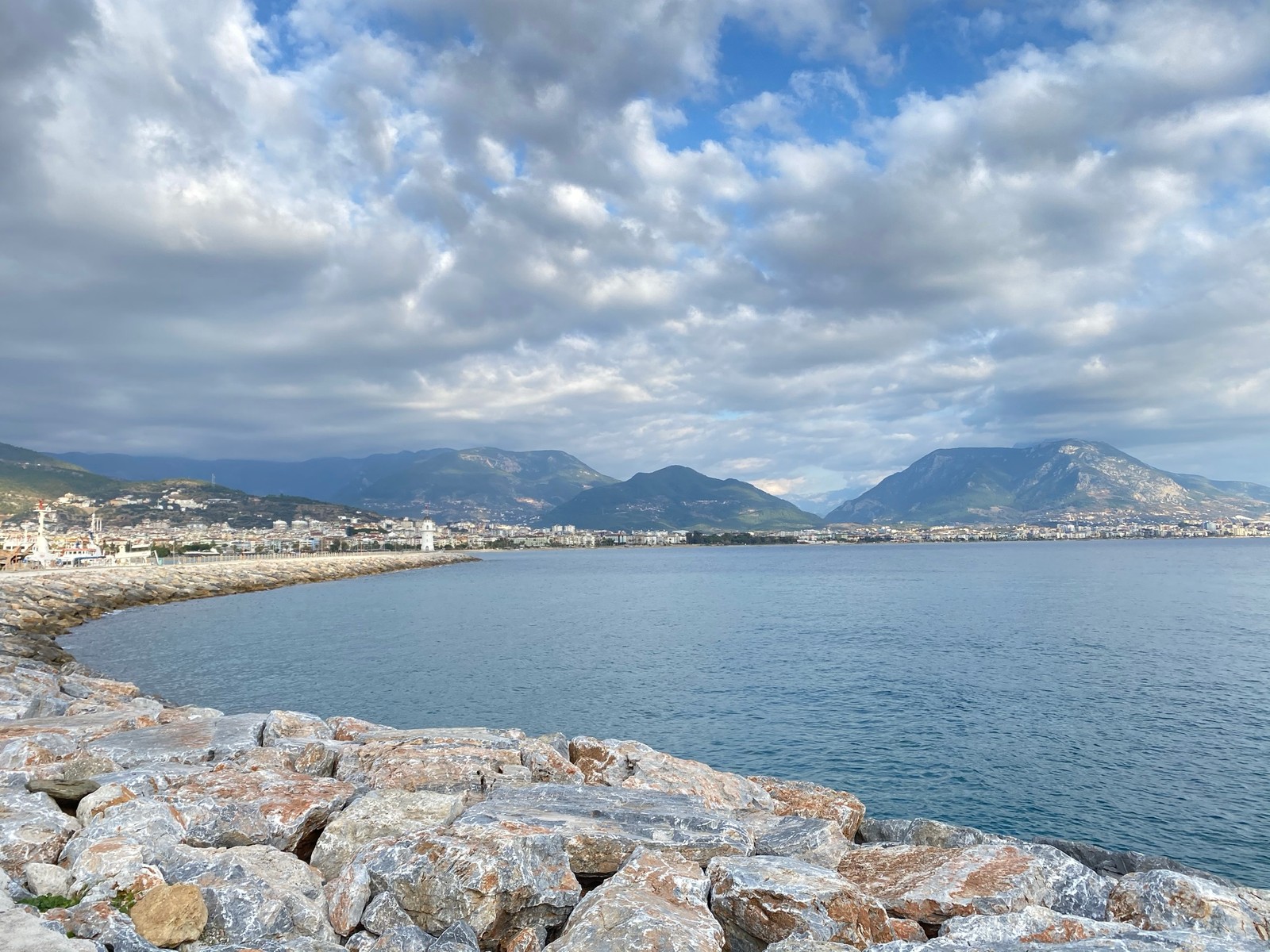 Une vue d'une plage avec des rochers et un plan d'eau (kizilkule, nuage, eau, ressources en eau, azur)