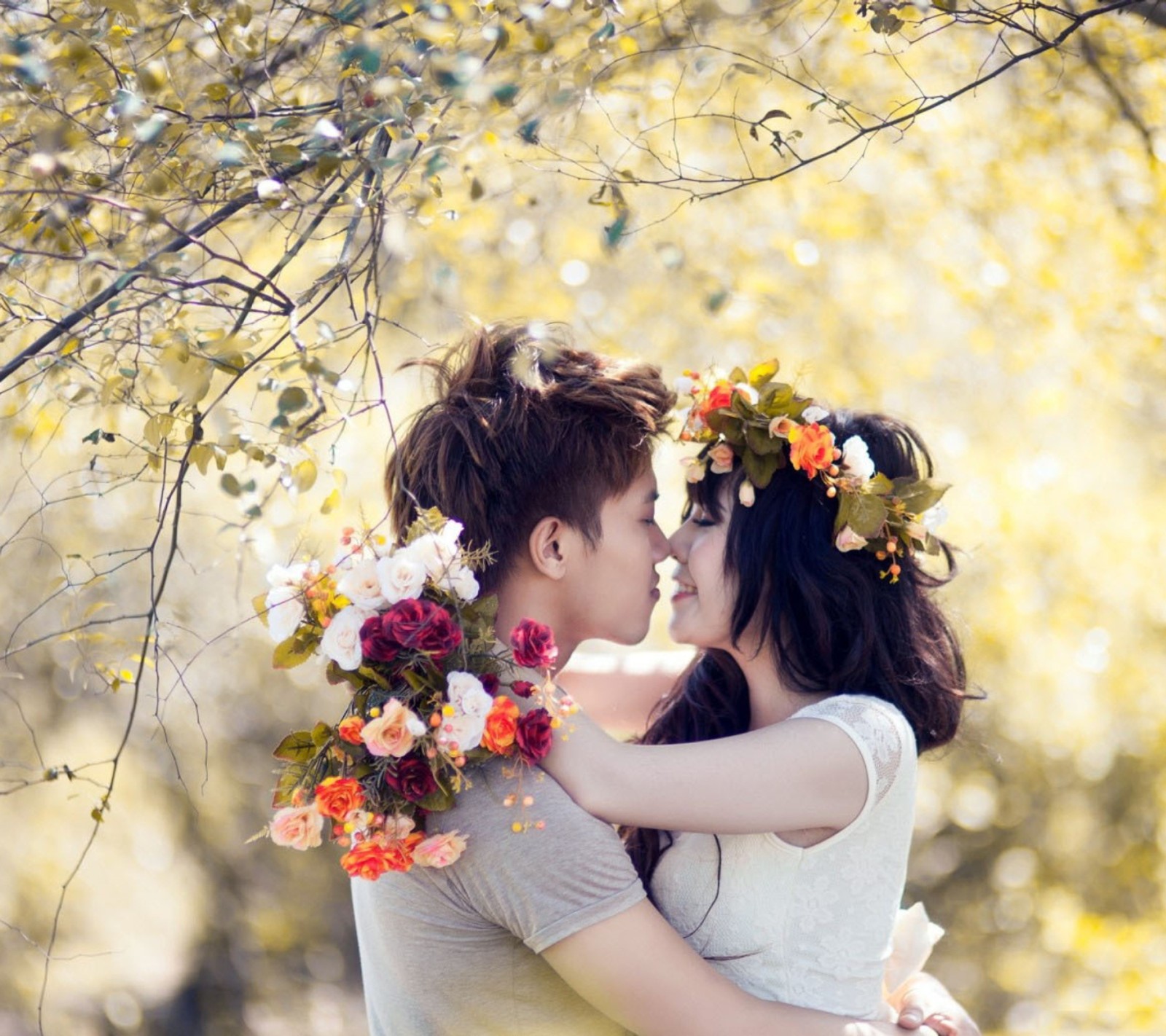 Un couple amoureux s'embrasse dans un parc avec des fleurs dans les cheveux (génial, amour)