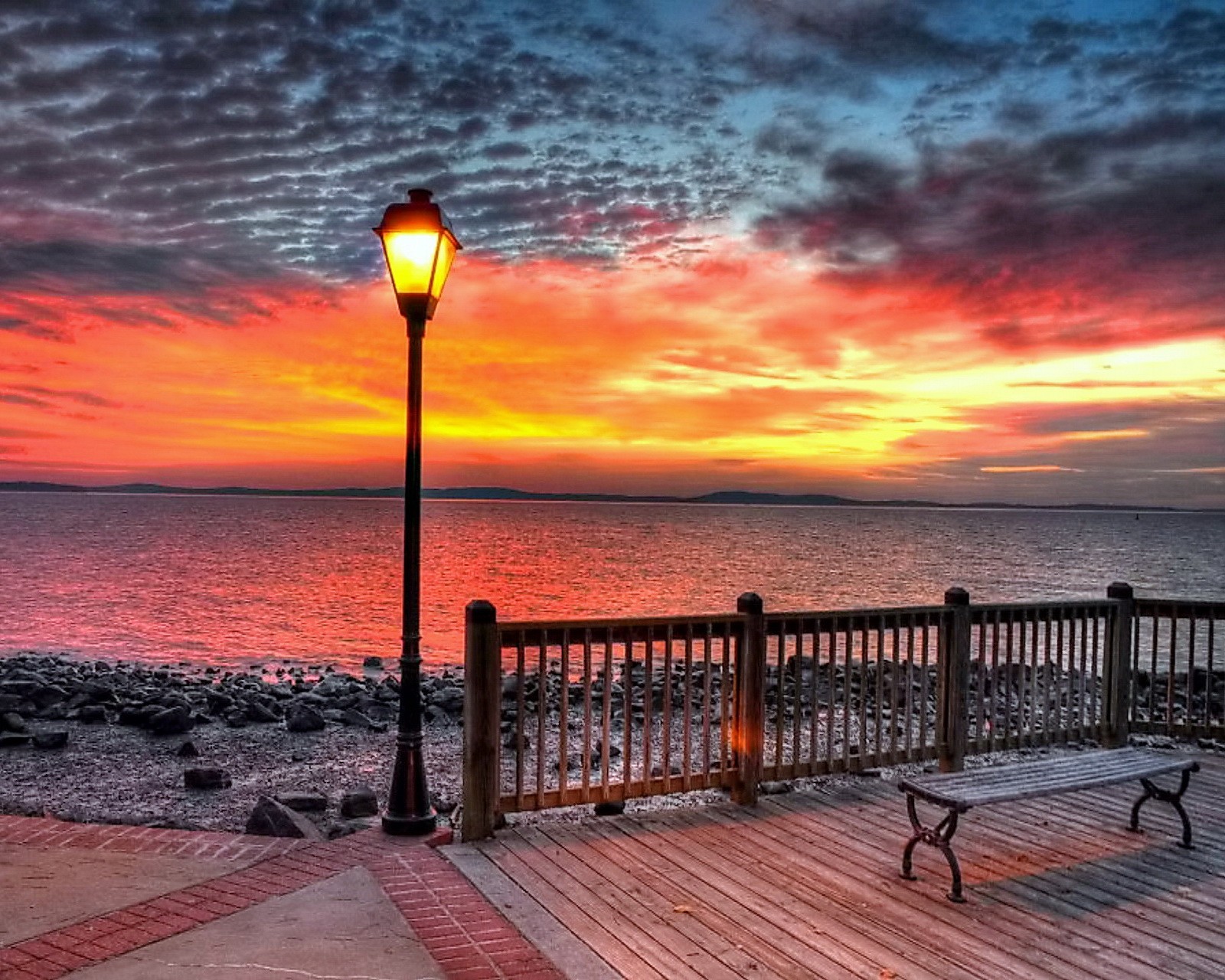 Coucher de soleil sur l'océan avec un banc et un lampadaire (incroyable, plage, coucher de soleil)