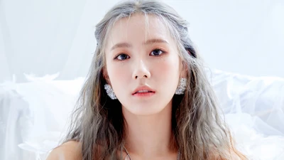 Miyeon von (G)I-DLE mit silbernem Haar und eleganten Ohrringen, die einen fesselnden und ätherischen Look verkörpert.