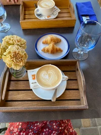 Morgengenuss: Kaffee und Croissants auf einem Holztablett