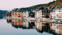 Reflexiones vespertinas de Dinant: Una serena escena junto al río