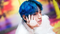 Kim Tae-hyung de BTS con cabello azul y accesorio floral