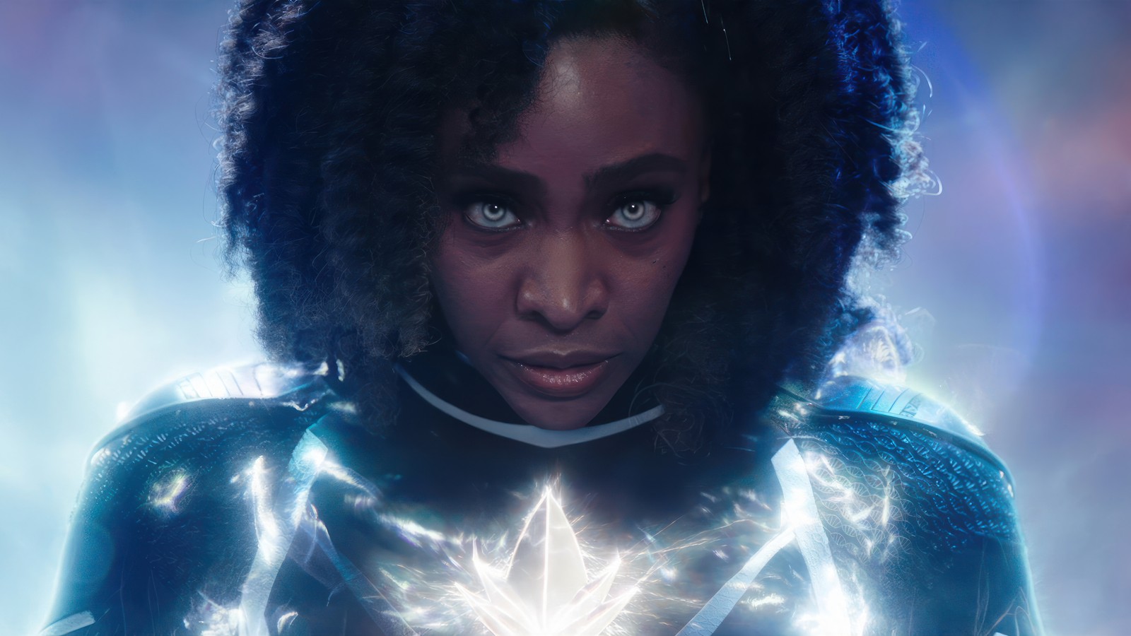 Una mujer con un atuendo azul sosteniendo una estrella en sus manos (los maravillas, película, marvel, monica rambeau, teyonah parris)