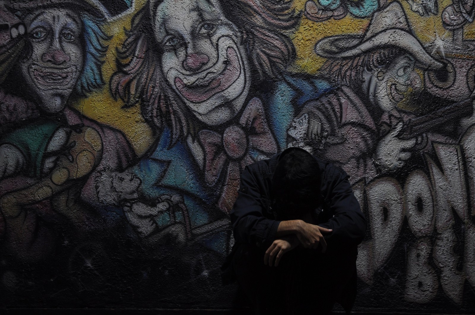 Grafiti en la pared de un edificio con una persona sentada en el suelo (grafiti, arte callejero, pintura, arte, mural)