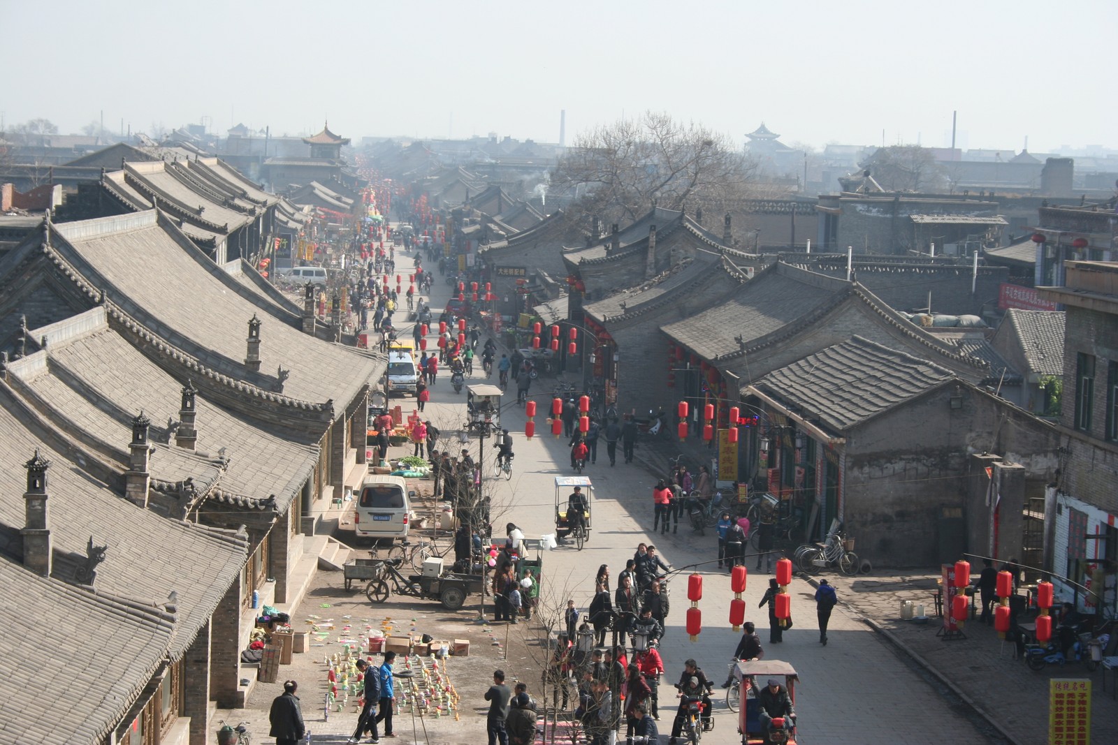 Jirafas caminando por una calle en una aldea china (área urbana, pueblo, ciudad, calle, edificio)