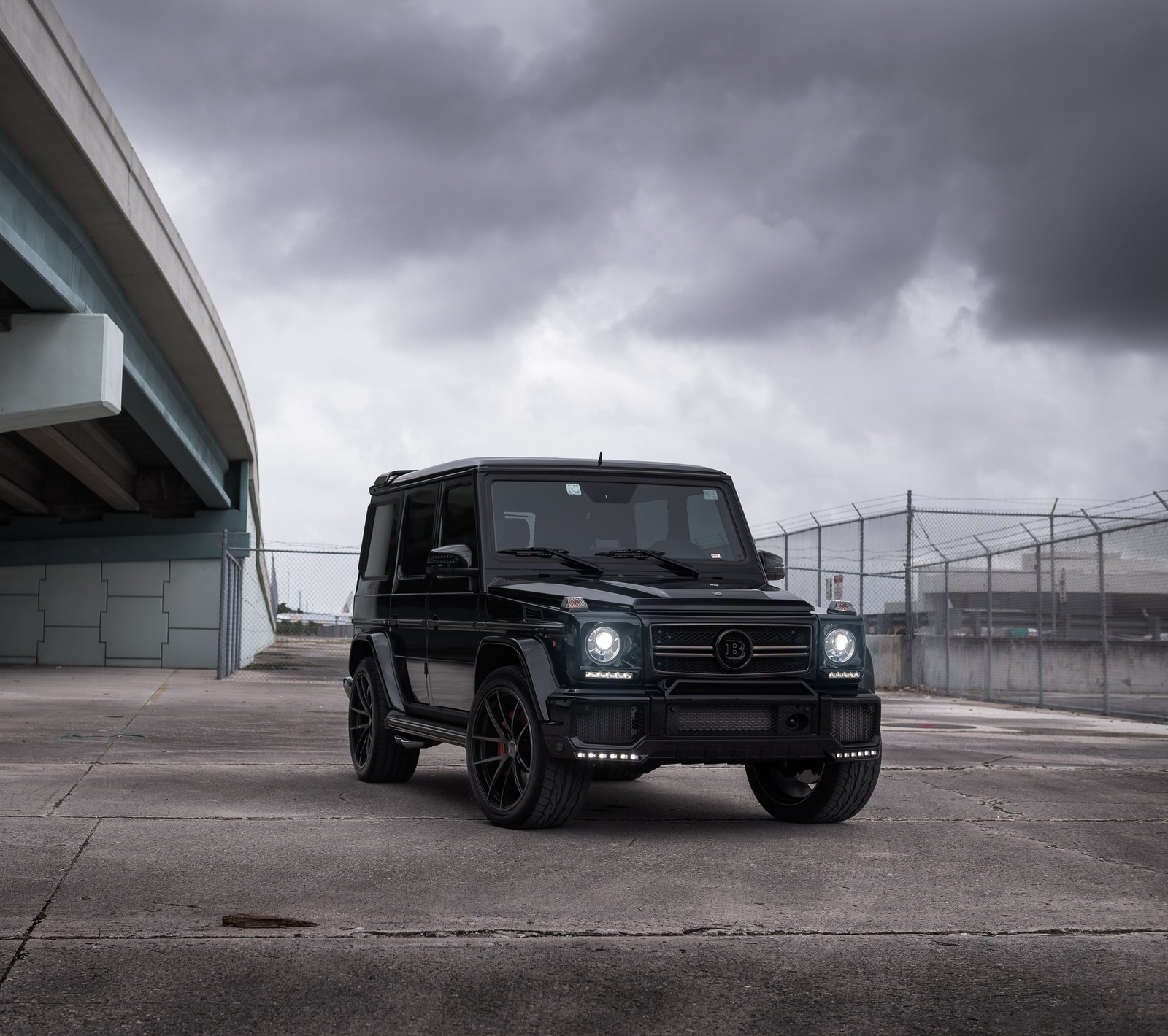 Arafed black mercedes g - class parked in front of a bridge (black, brabus, gelandewagen, mercedes)