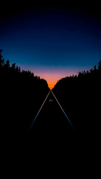 Vías de tren bajo un vibrante cielo de atardecer