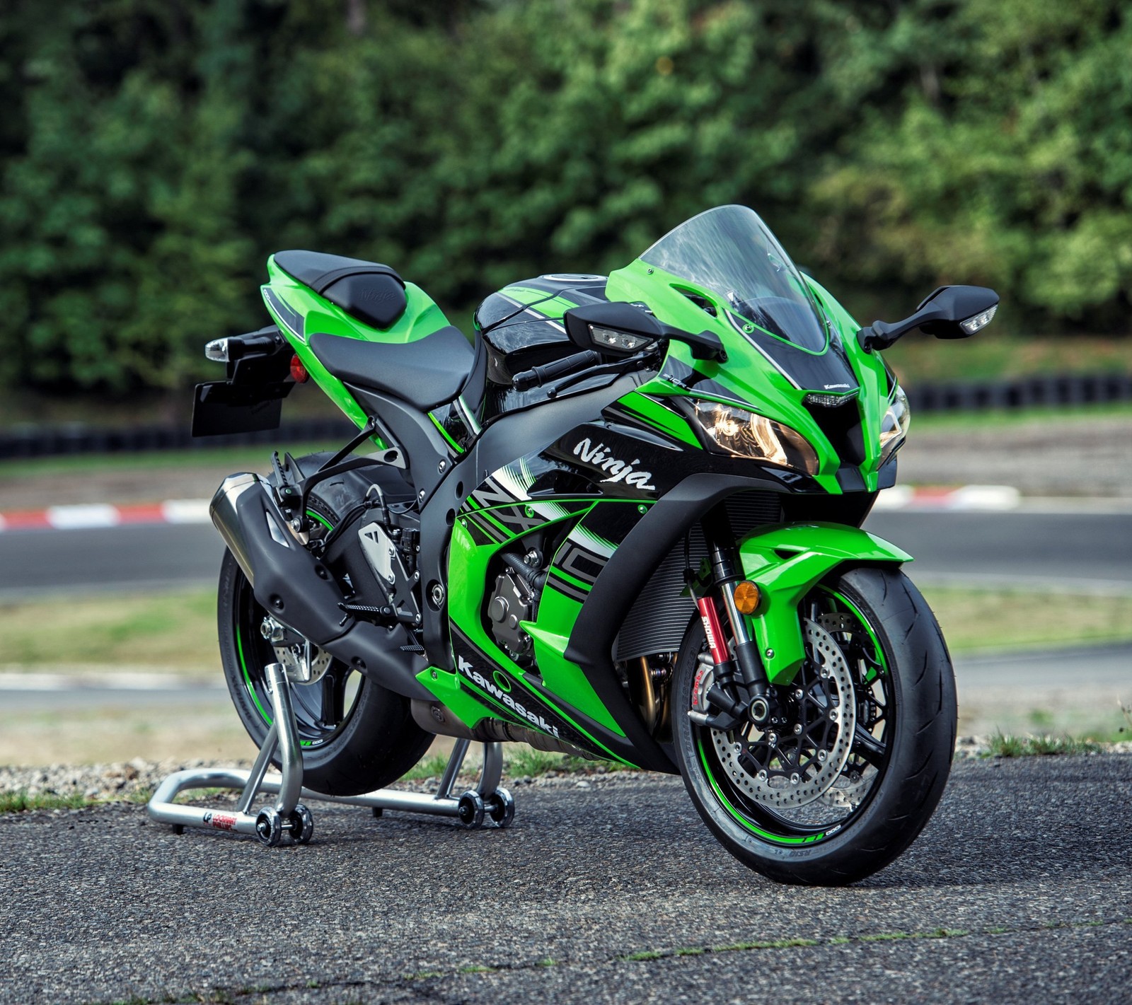 A close up of a green motorcycle parked on a street (black, green, kawasaki, motorbike, ninja)