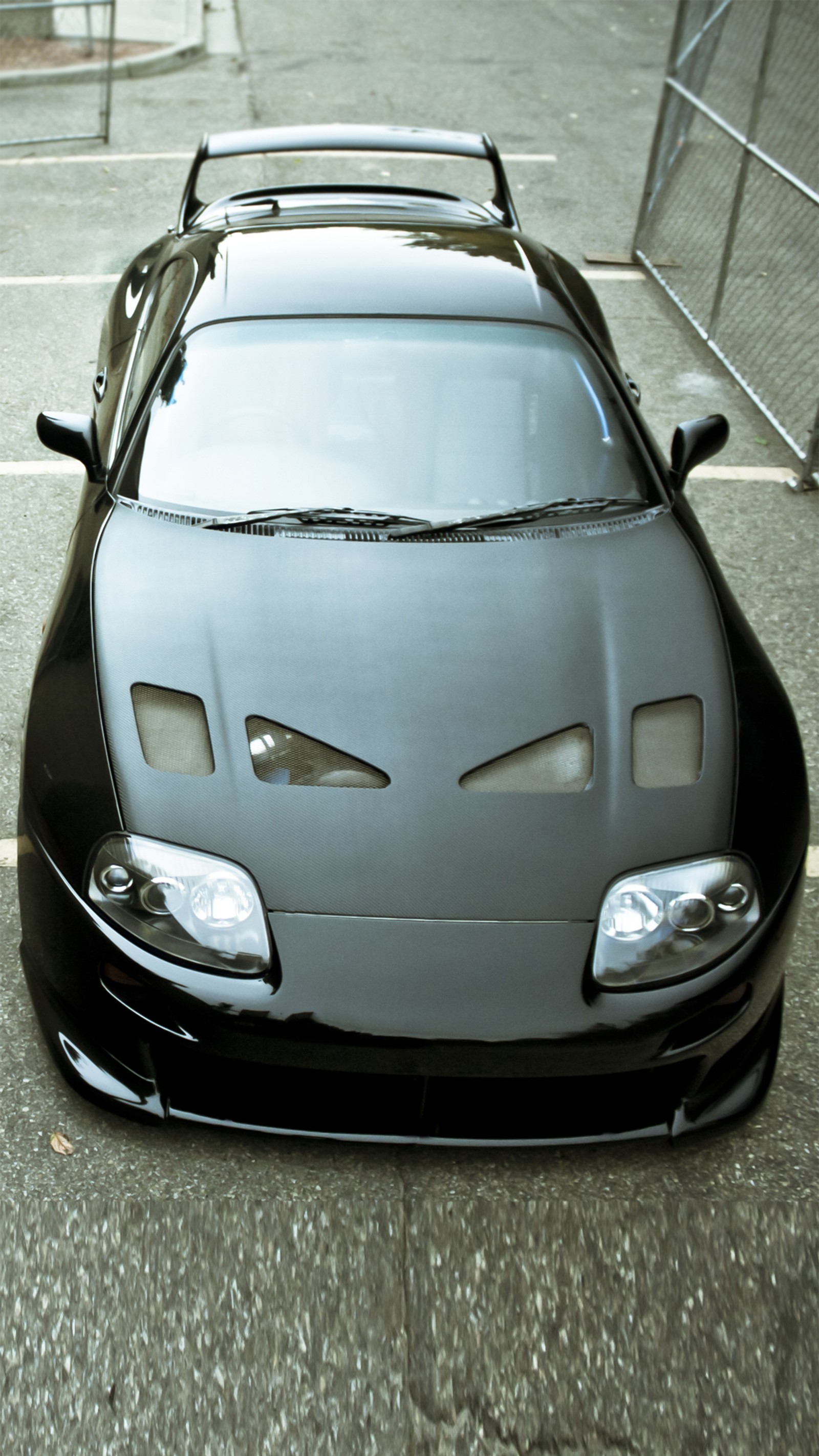 Arafed black sports car with eyes on the hood parked in a parking lot (black, car, engine, power, speed)