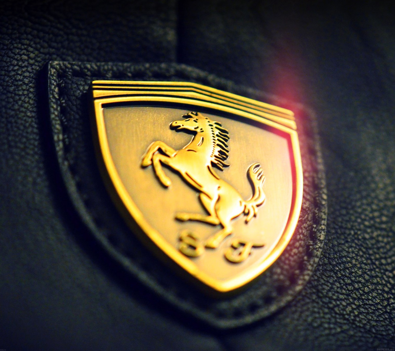 A close up of a ferrari badge on a black leather jacket (car, ferrari)