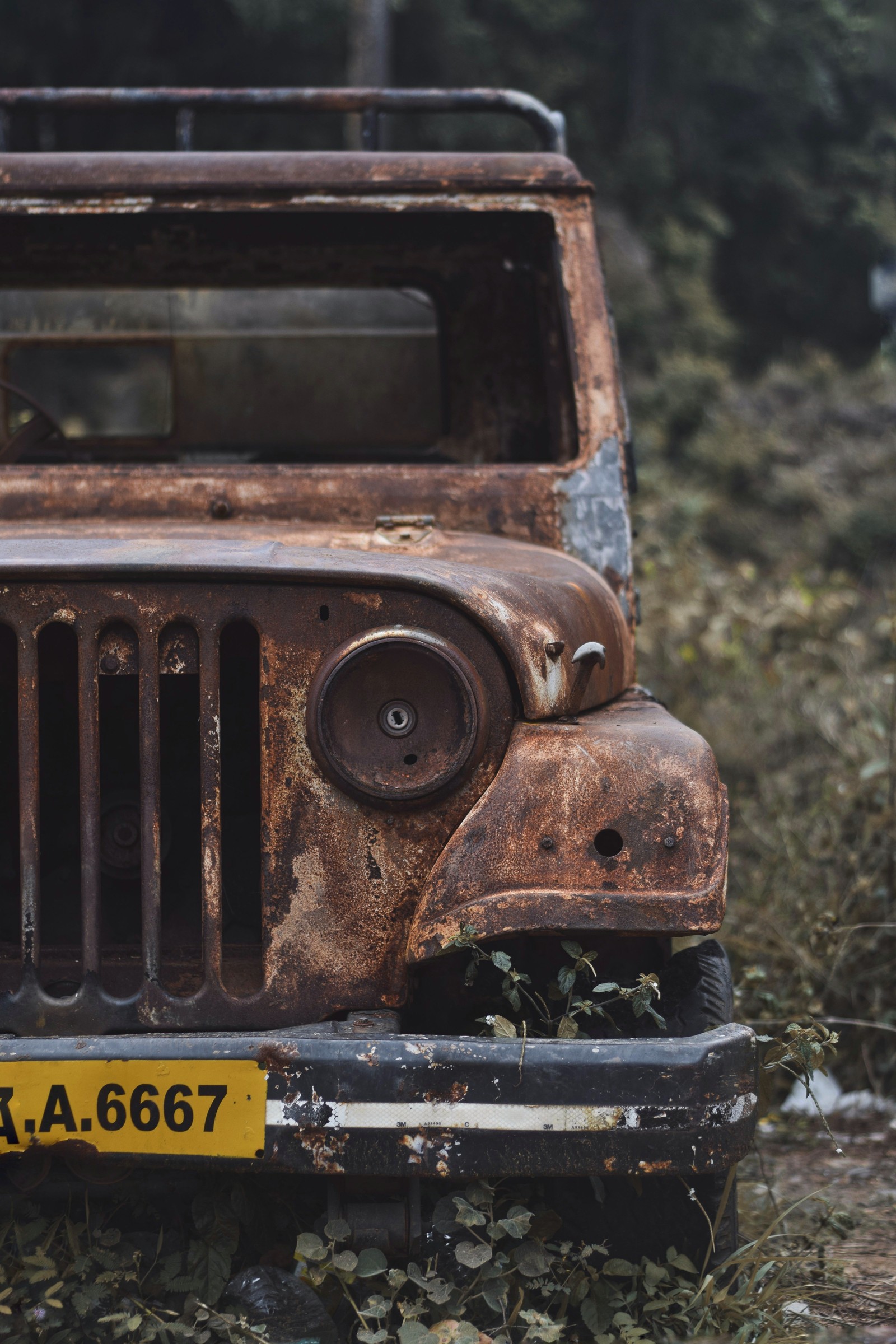 Um jipe velho e enferrujado com placa em uma floresta com árvores (defensor, jogos, jeep, terra, legado)