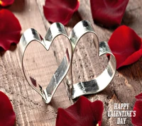 Cortadores de galletas en forma de corazón rodeados de pétalos de rosa para el Día de San Valentín