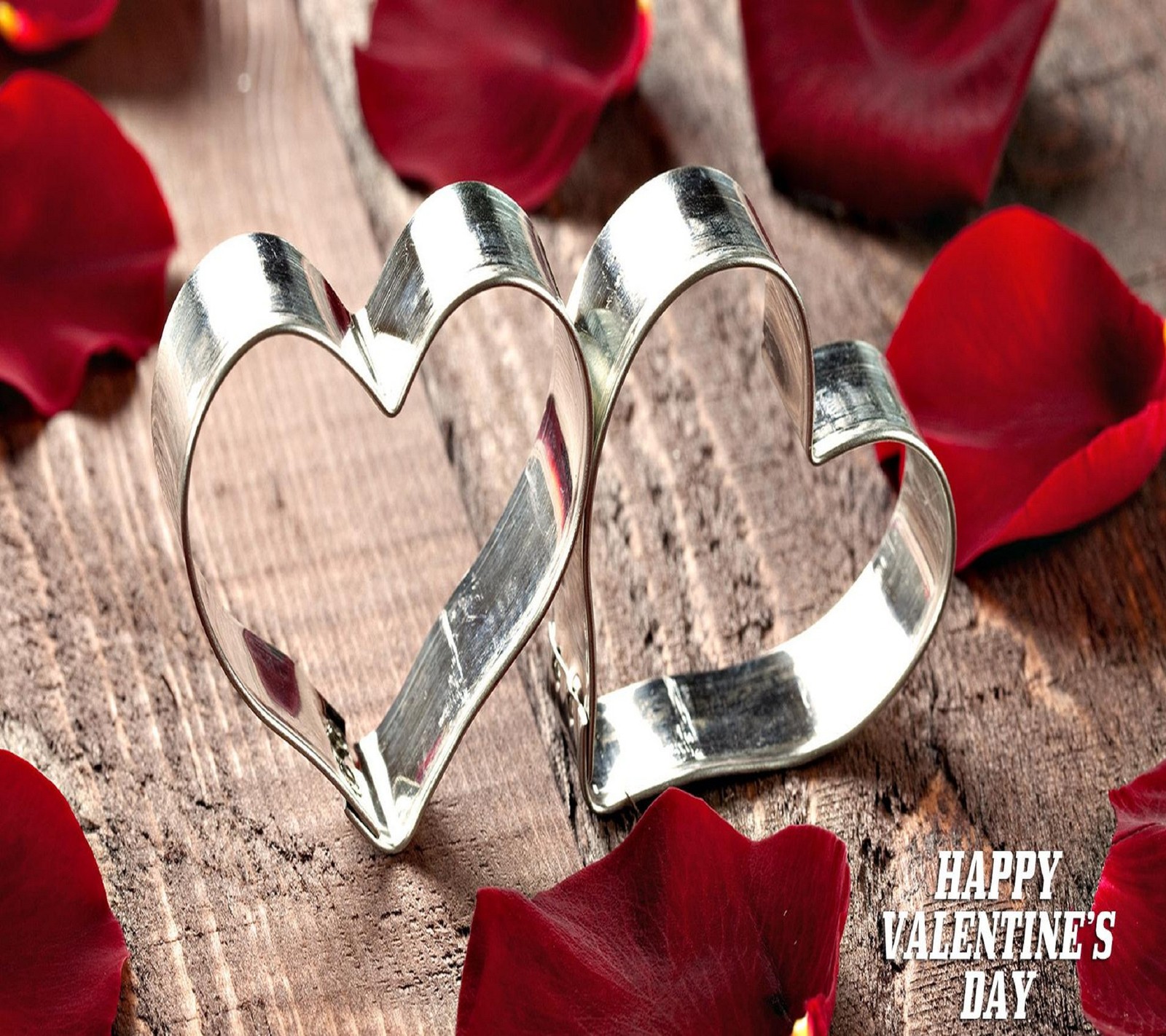 Hay dos cortadores de galletas en forma de corazón sobre una mesa de madera (corazones, te quiero, amor, corazones de amor, día de san valentín)