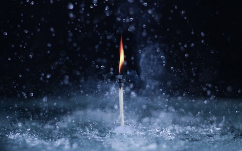 A close up of a lit matchstick in the water (rain, water, night, sky, nature)