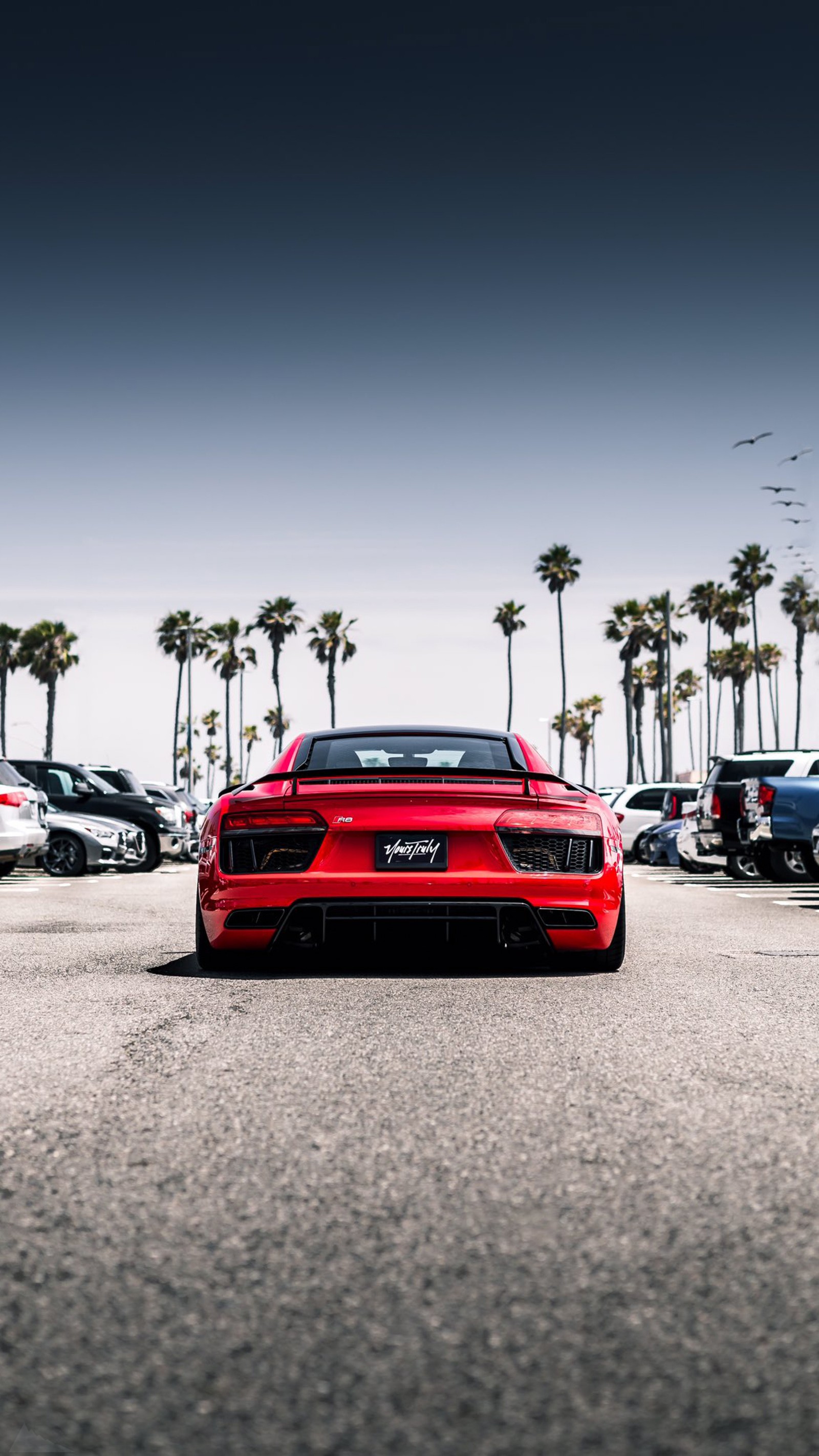 Um carro esportivo vermelho árabe estacionado em um estacionamento com palmeiras (lamborghini aventador, carros, audi, lamborghini, supercarro)