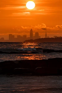 Pôr do sol dourado sobre o horizonte e as ondas do oceano