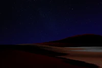 Noche estrellada sobre dunas del desierto