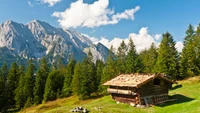 Cabane en rondins alpine entourée de paysages montagneux majestueux et de forêts luxuriantes