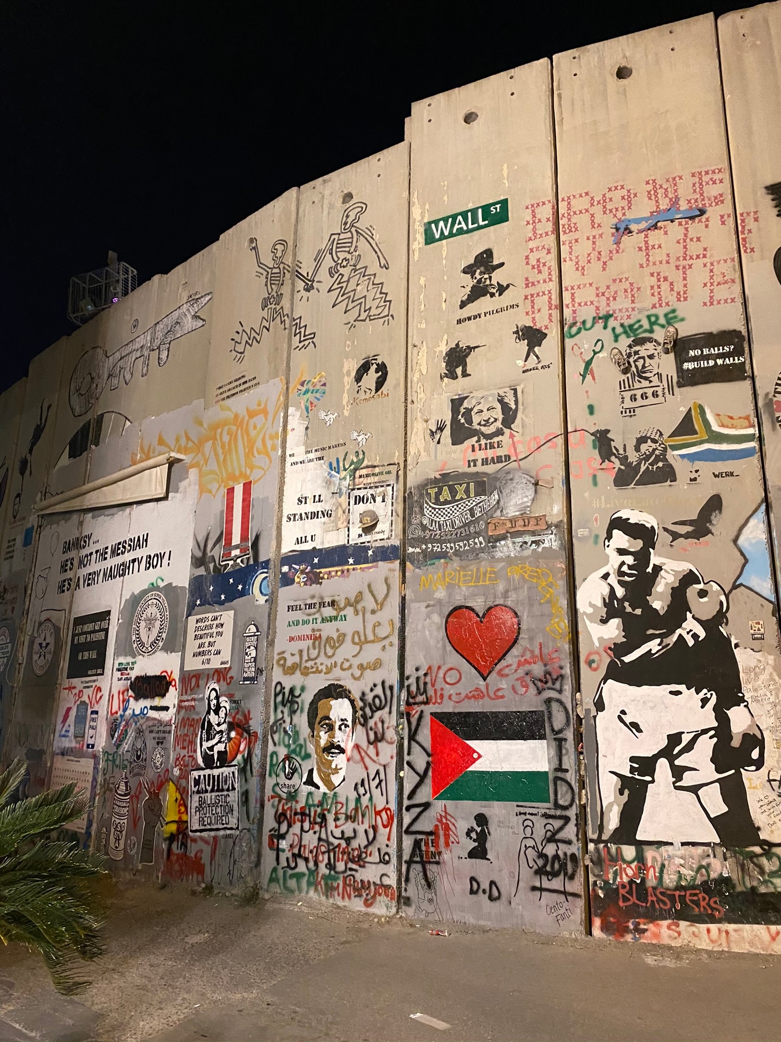 Graffiti sur le mur avec un panneau de rue et une flèche rouge (mur, israël, israel, art, graffiti)