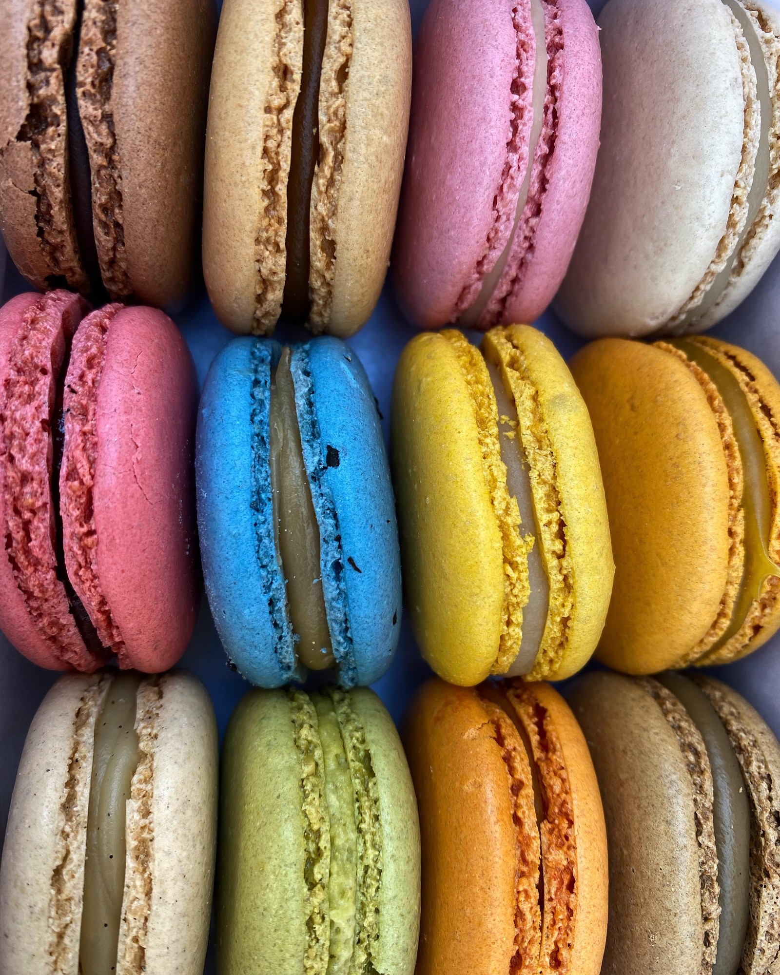 Acercamiento de una caja de macarons de diferentes colores (macarón, postre, horneado, comida, ligero)