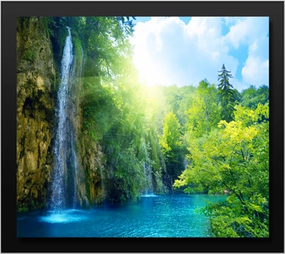 Cascade ensoleillée se déversant dans un lac bleu tranquille entouré d'une verdure luxuriante