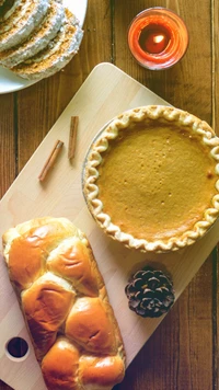 Festin de Thanksgiving : Tarte à la citrouille et petits pains frais sur une table rustique