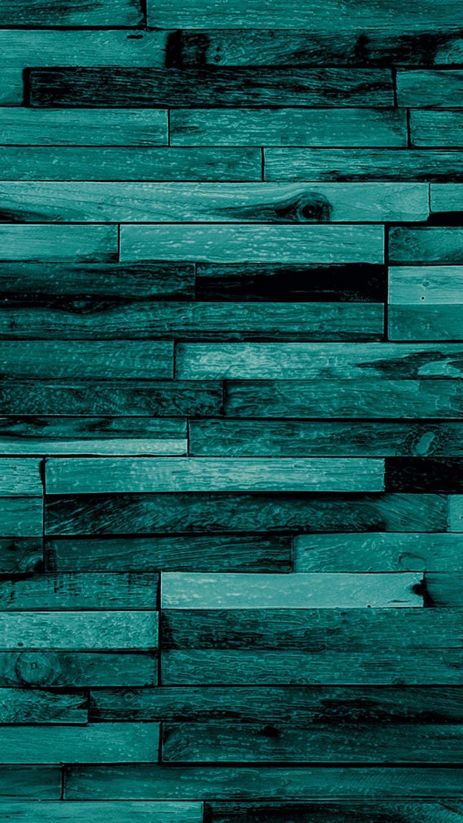 Un gros plan d'un mur en planches de bois avec une lueur verte (bleu, mur, bois)