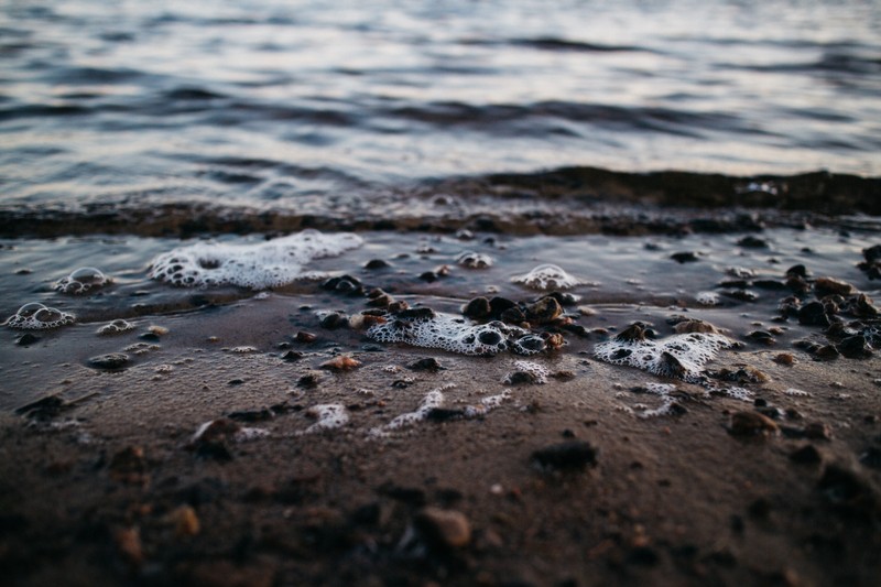 Близкий план пляжа с множеством камней и воды (вода, море, побережье, волна, природная среда)