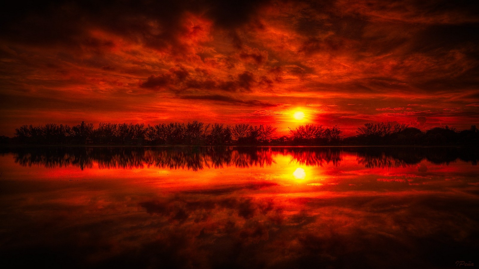 Un coucher de soleil rouge sur un lac avec des arbres et des nuages (ciel rouge, coucher de soleil, crépuscule, nature, lever de soleil)