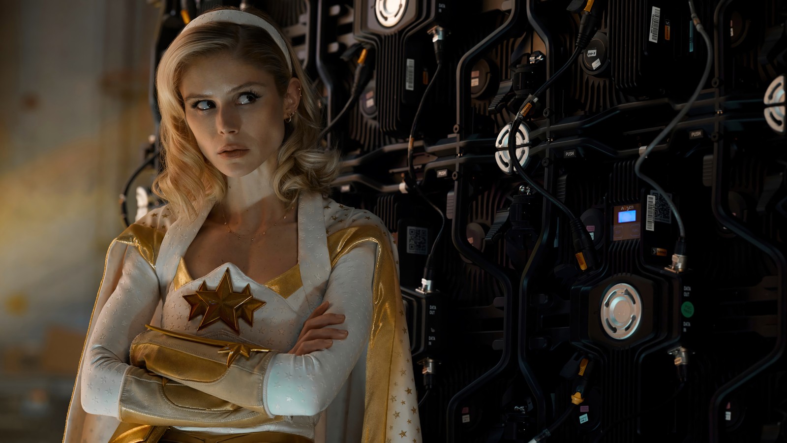 Mujer árabe en un traje blanco y dorado de pie frente a una pared (la serie the boys, the boys series, luz de estrellas, erin moriarty, temporada 3)