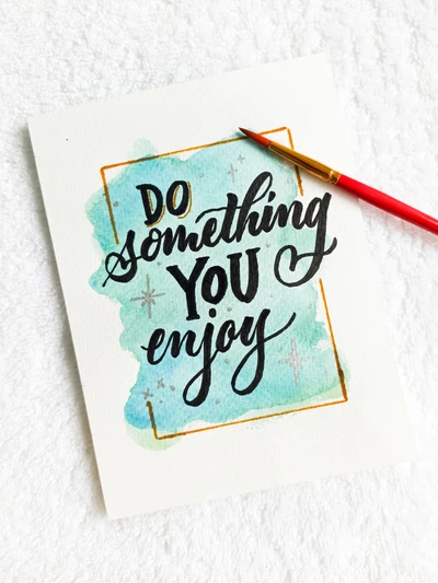 Handwritten Calligraphy on Aqua Background: 'Do Something You Enjoy'