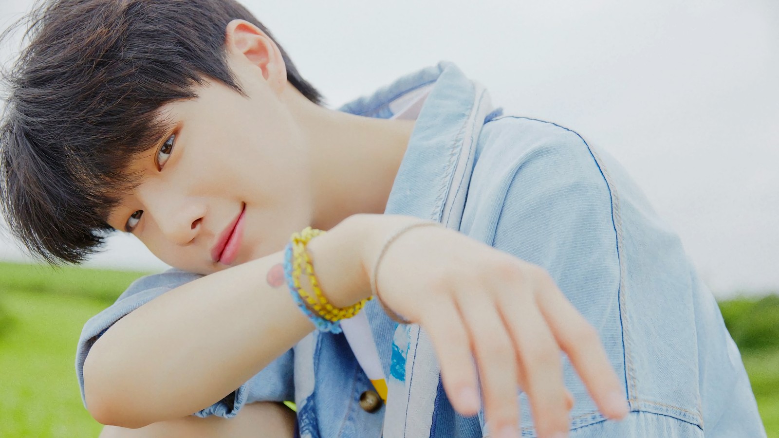 Jeune homme avec une montre au poignet dans un champ (x1 k pop, x1 kpop, kpop, seungyoun, cho seung youn)