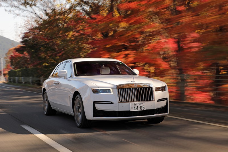 Белый rolls royce едет по дороге с деревьями на фоне (роллс ройс призрак, rolls royce ghost, 2020, 5k, машины)