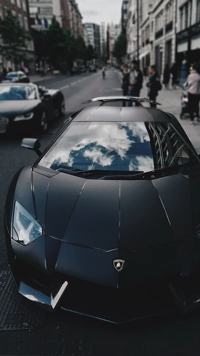 Sleek black Lamborghini Aventador parked on a city street, reflecting the sky in its windshield.