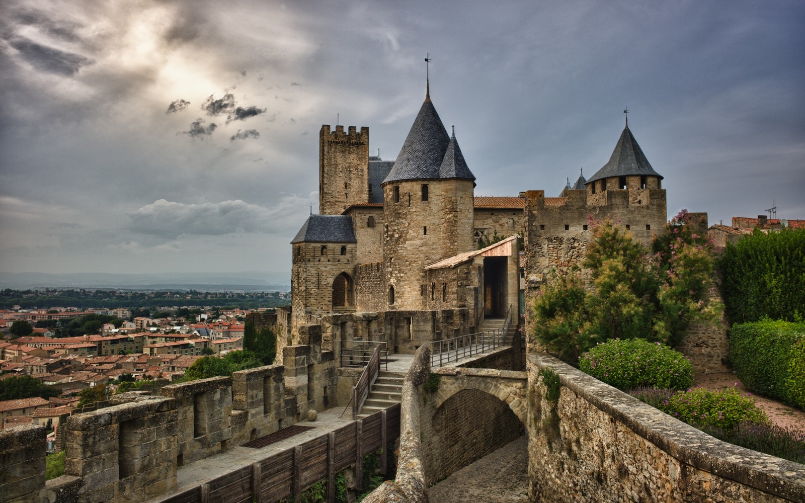 Vue d'un château avec un pont et un ciel nuageux (fortification, château, ville, point de repère, bâtiment)