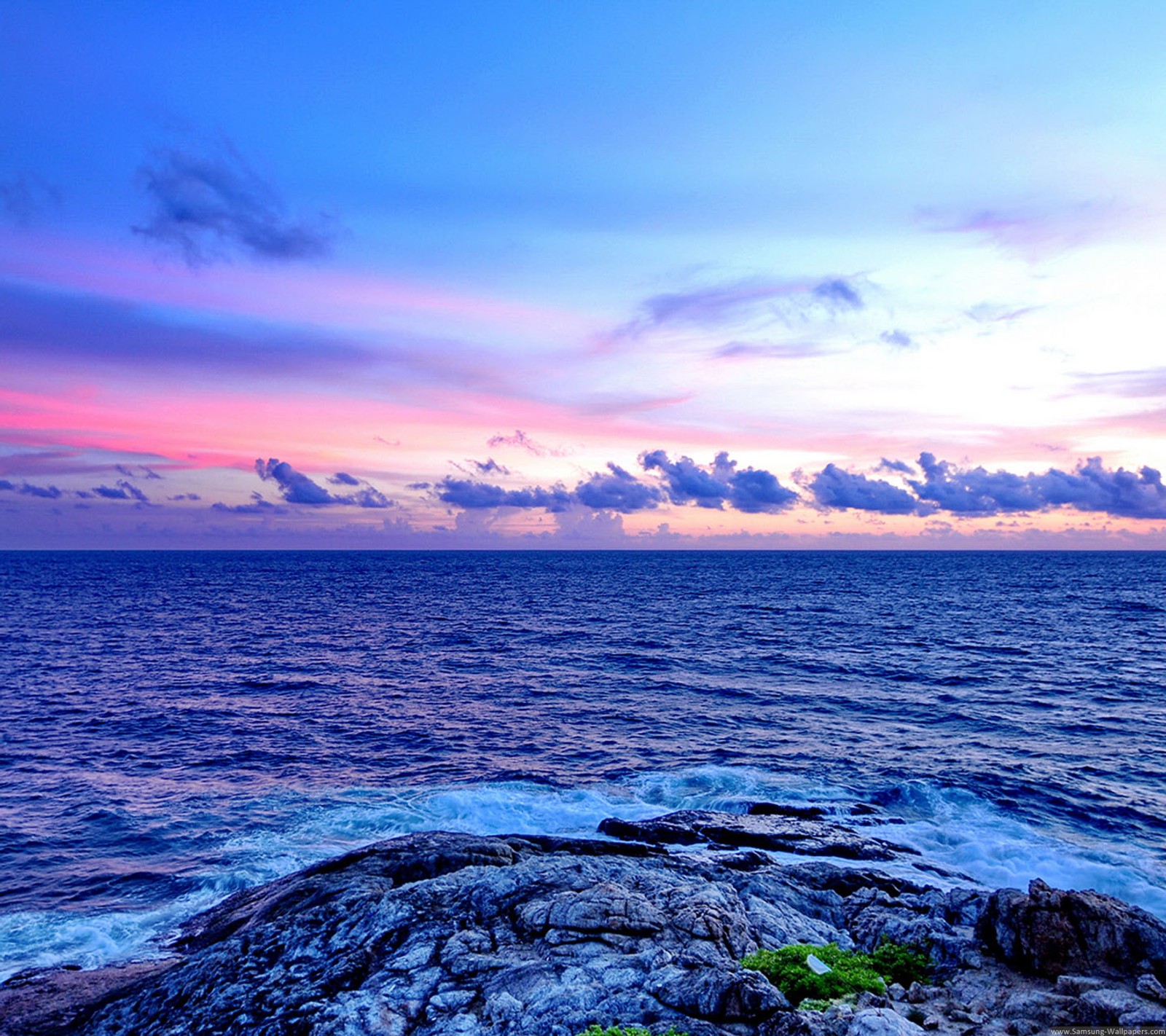 Una vista borrosa de una hermosa puesta de sol sobre el océano con un cielo rosa (azul, mar, cielo)