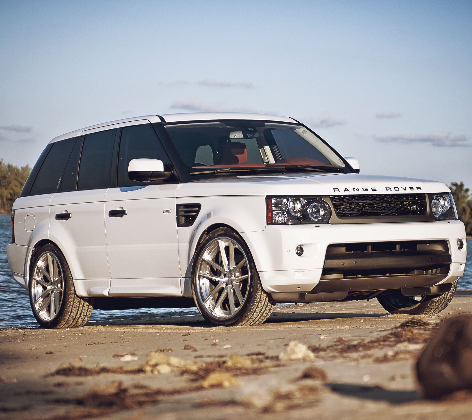 Arafed white land rover parked on a beach near the water (4x4, britain, england, range rover, white)