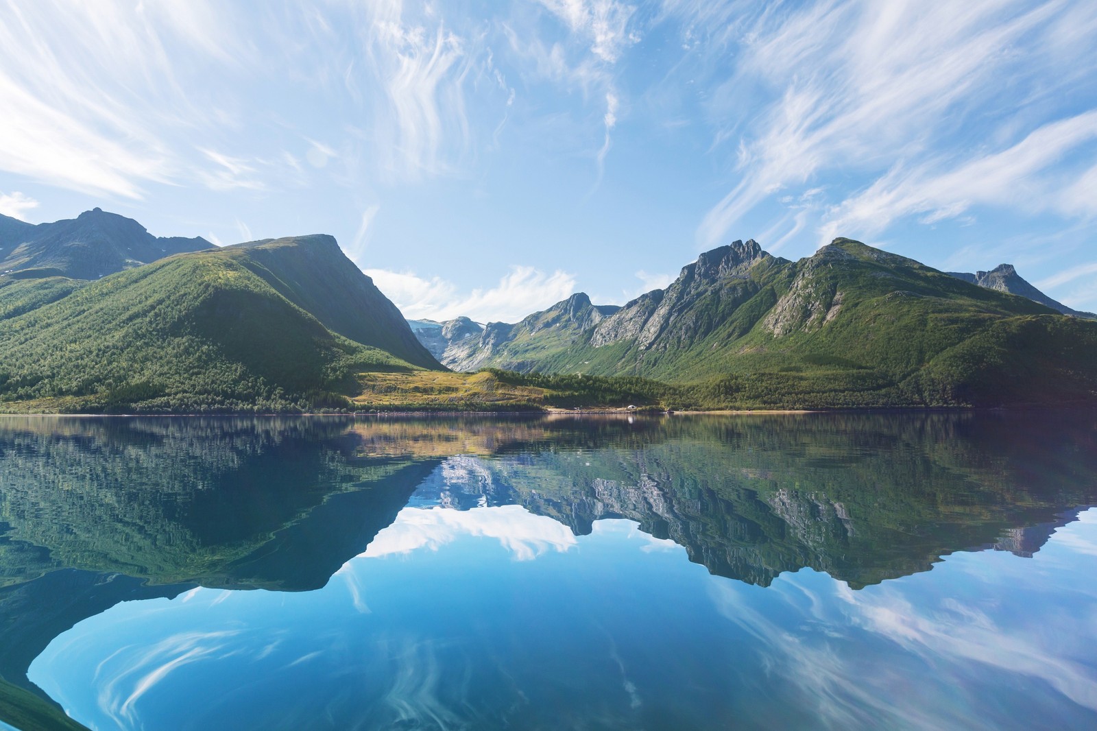 Una vista de un lago con montañas al fondo (fiordo, noruega, reflexión, naturaleza, montaña)