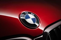 Primer plano del logo de BMW Serie 7 sobre una superficie roja brillante