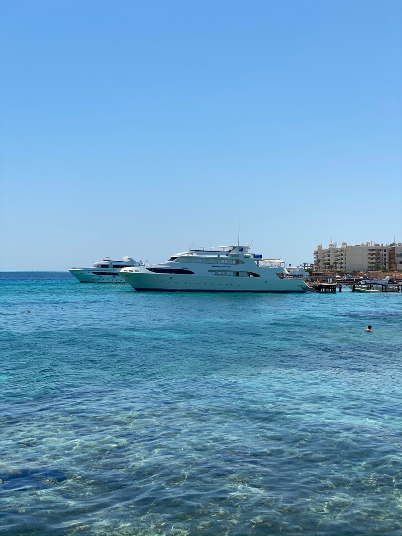 Большая лодка находится в воде рядом с пляжем (море, вода, водное судно, водный путь, горизонт)