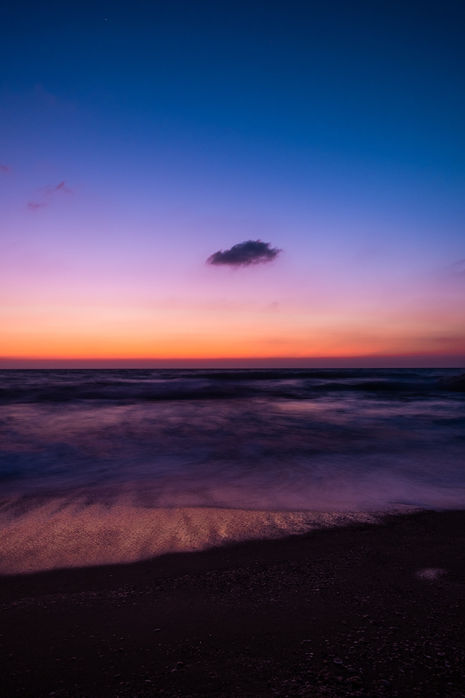 Vue floue d'une plage avec un nuage solitaire dans le ciel (lever de soleil, plage, design, ciel, crépuscule)