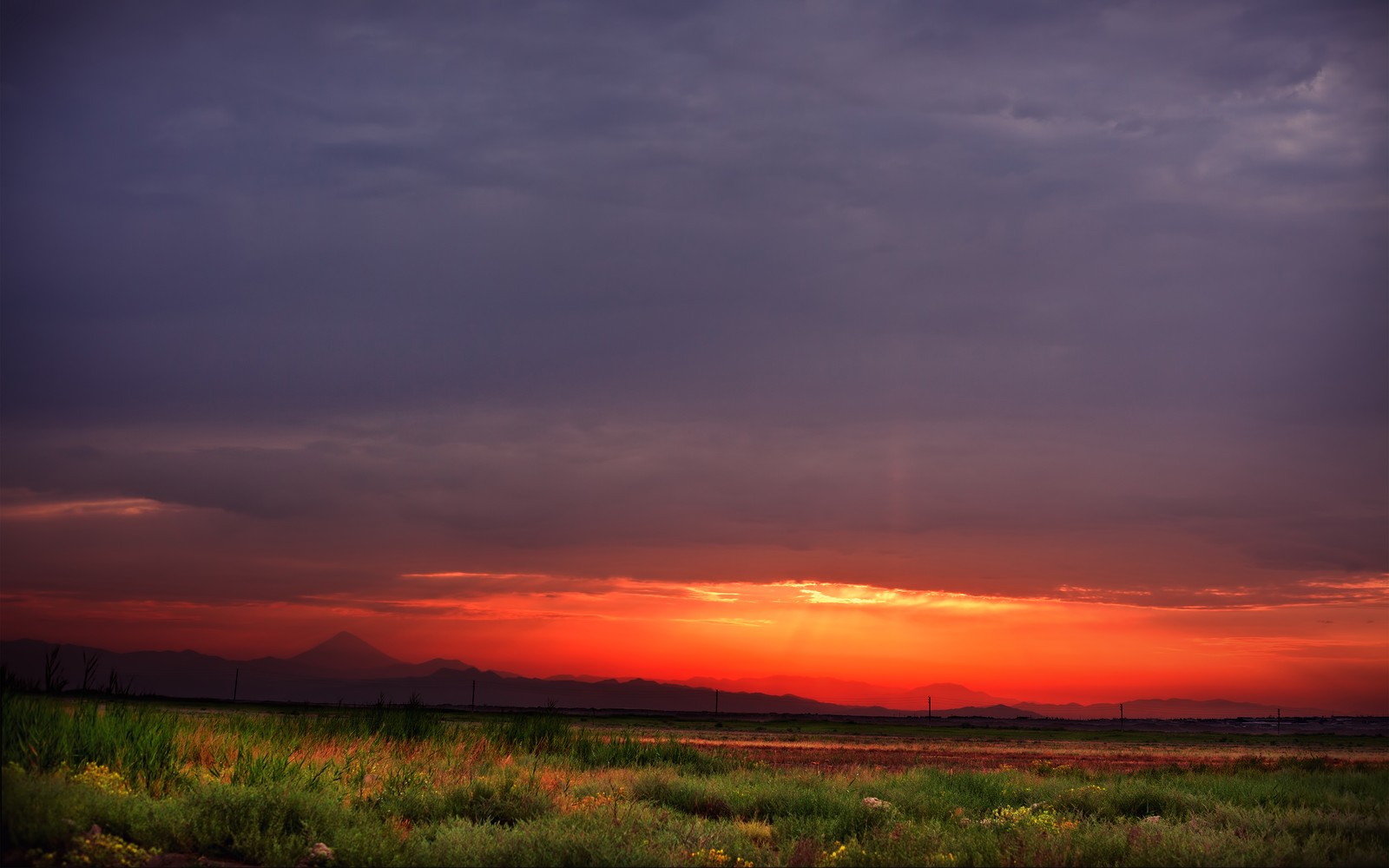 Vue d'un coucher de soleil avec un champ et des montagnes en arrière-plan (coucher de soleil, nature, paysage, crépuscule, nuage)